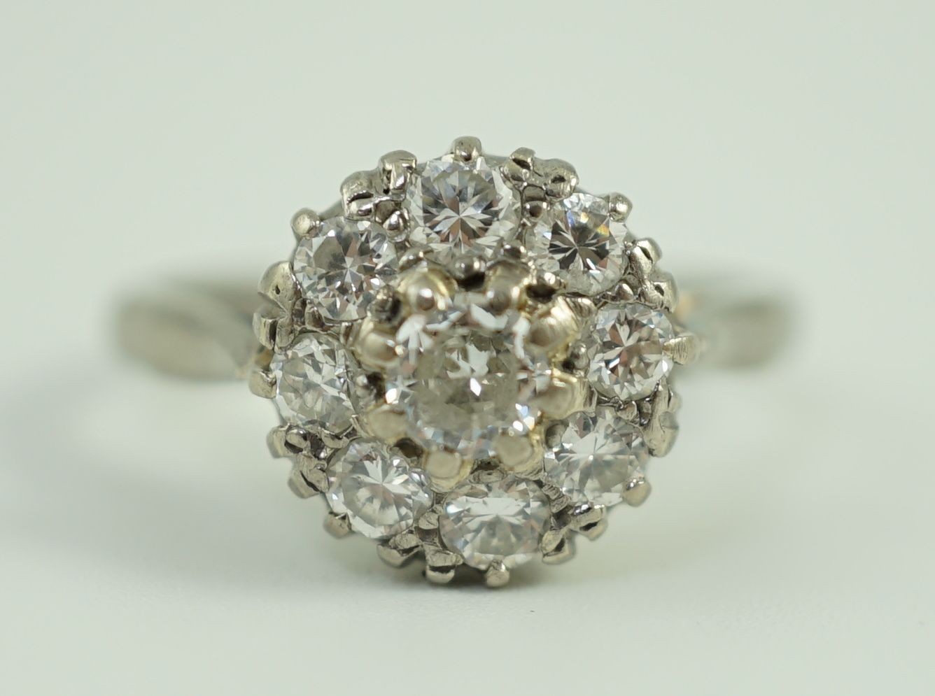 An 18ct white gold and nine stone diamond flower head cluster ring